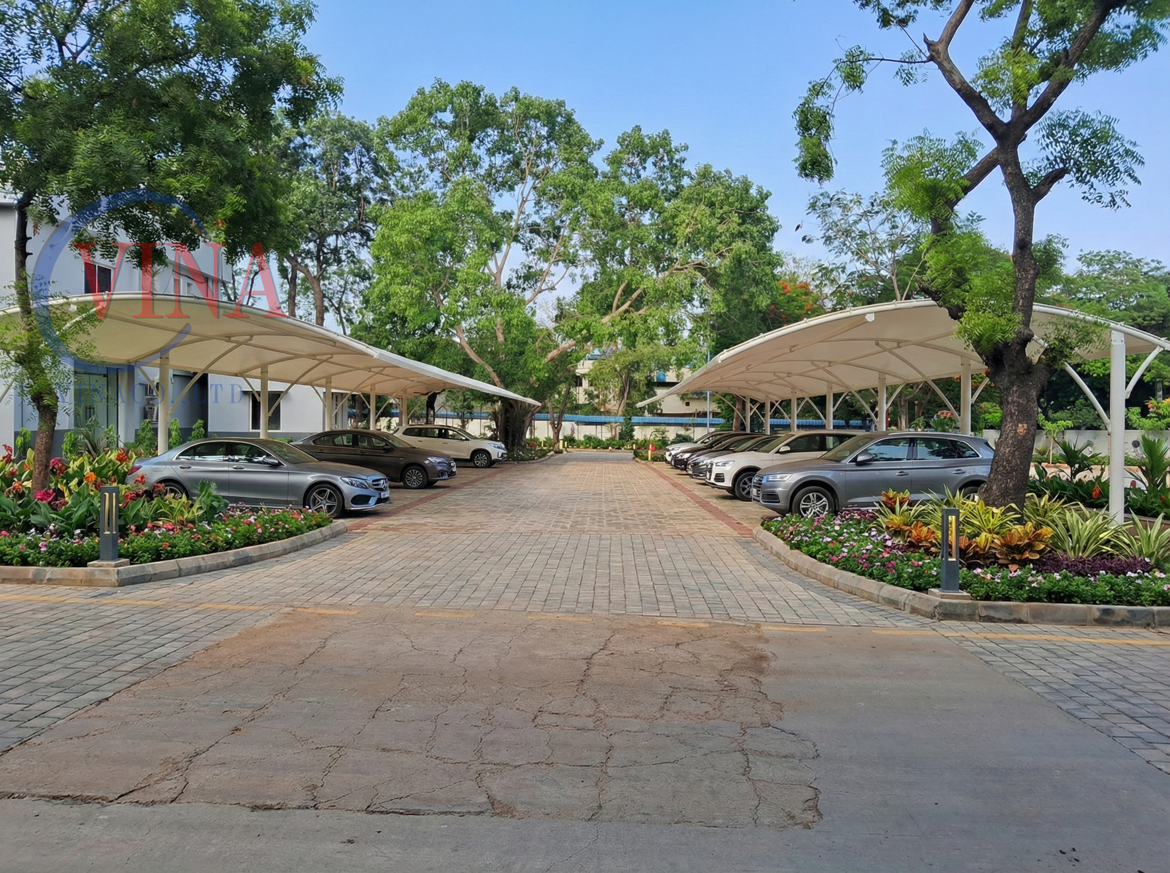 Bãi đỗ xe ô tô chung cư cao cấp với mái che bạt căng hiện đại và nhiều cây xanh